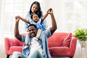 Portrait of enjoy happy love black family african american father and mother with little african girl child smiling and play having fun moments good time in room at home