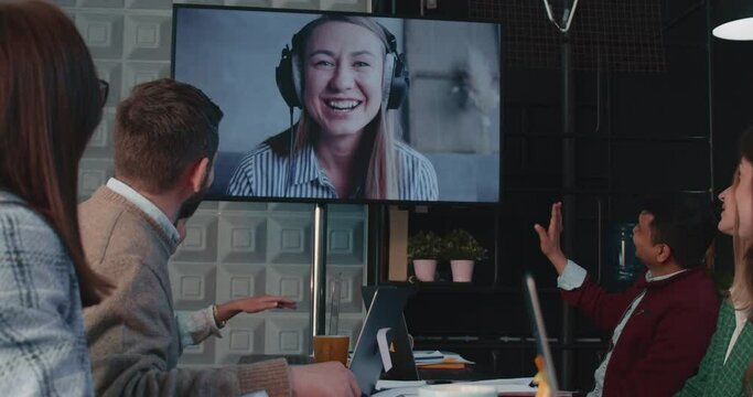 Team of business people wave, talk to female CEO, manager via web conference, video call at office meeting slow motion.
