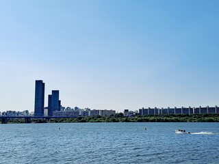 Fototapeta premium Dynamic boat tour on the Han River and panoramic view of high rise modern buildings in Seoul