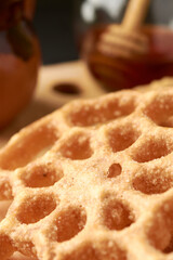 Mexican buñuelos or puñuelos with a circular shape, at the bottom coffee and honey to enjoy, placed on a wooden base.