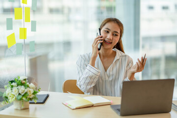 business woman talking on the phone at her desk in the office
