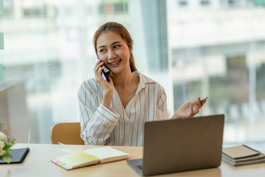 business woman talking on the phone at her desk in the office