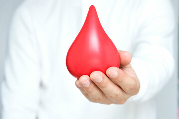 healthy man's hand holding blood symbol Blood Donation Help and Health Concepts.