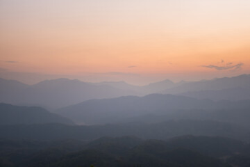 Obraz na płótnie Canvas Mountain range with visible silhouettes through the morning colorful fog.