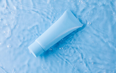 White cosmetic bottles in a blue pool. Moisturizing lotion for skin and body and spa treatments. 