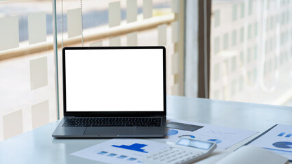 Laptop computer with blank white screen on table in the office. mock up.