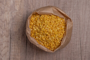 Whole grains of soybeans in paper bags on wooden floor