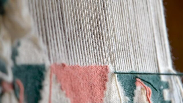 Close up, A woman weaving traditional handmade carpet. Turkish carpet weaving, a female hands weaving a carpet, rug. Needlework. Carpet-makers work. 4k, slow motion footage with natural sound effect.