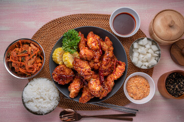 Gang Jeong chicken or crispy and tender Korean fried chicken smothered in a sticky, spicy red sauce Served with kimchi, dipping sauce, rice and sweet corn.