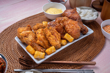 Korean style crispy fried chicken with dipping cheese and rice cakes.
