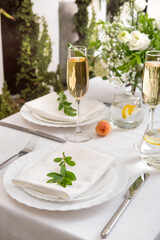 Wedding teble decoration with white flowers, glasses and white napkins. Elegantly decorated table...