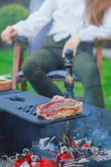 T-bone steak on barbecue grid over hot charcoal