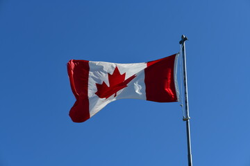 canadian flag waving against sky