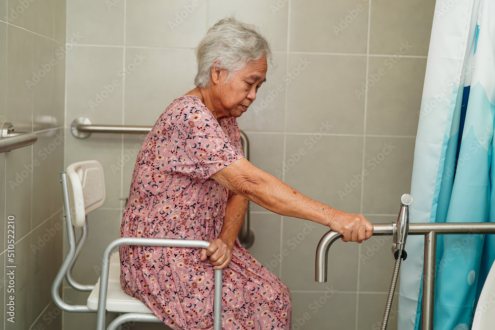 Wall mural asian senior or elderly old lady woman patient use toilet bathroom handle security in nursing hospit