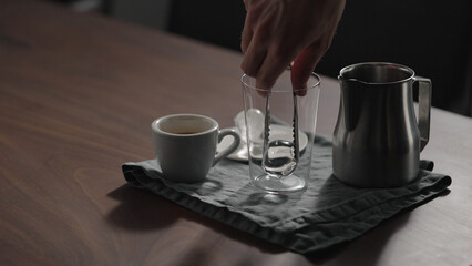 making espresso tonic in tumbler glass on walnut table