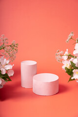 Natural minimal beauty pedestal. Empty cosmetics podiums on pink background with flowers for product