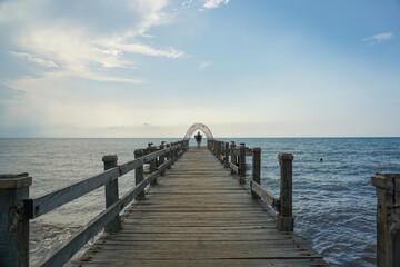Fototapeta premium A Woman standing at the bridge at Lovina Beach, Bali, Indonesia.