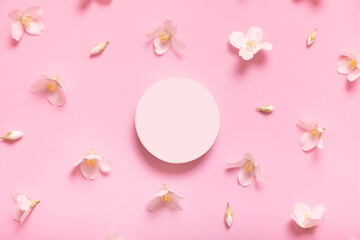 Fototapeta na wymiar Top view podium or pedestal with jasmine flowers on pastel pink background. Empty cosmetics podiums for product or jewerly lay flat
