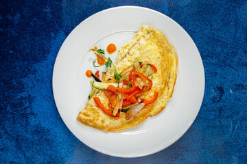 fresh omelet with vegetables on the white plate