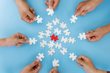 Hands of diverse people assembling jigsaw puzzle, team put pieces together searching for right...