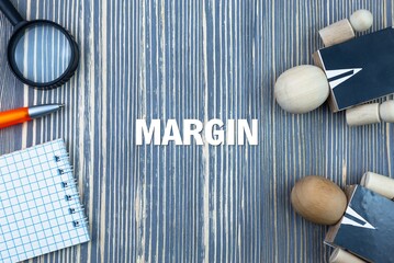 MARGIN - word (text) on a wooden background, notepad and pen with calculator. Business concept...