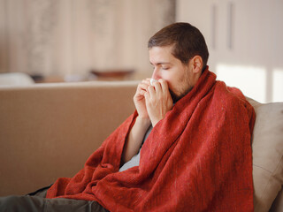 Coronavirus. Sick man of corona virus lying down in sofa and recovery from illness in home. Blowing...