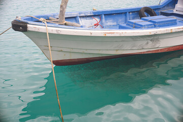 Fototapeta na wymiar 沖縄県宮古島の漁港 漁船の下の海に大漁の魚影 ミジュンの群れ