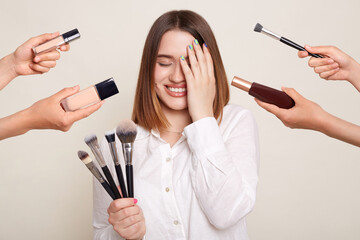 Image of the hands of several beauticians holding their respective equipment giving makeover to...