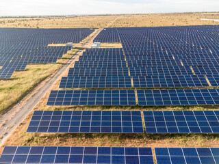 Aerial top view of a solar panels power plant. Photovoltaic solar panels at sunrise and sunset in...