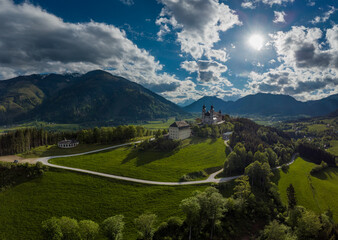 Fototapeta na wymiar Wallfahrtskirche frauenberg is a beautiful church in the middle of Austria, drone panorama view of a church next to enn river in central Austria on a sunny summer day.