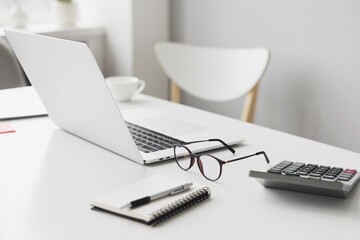 Accountant workplace, calculator, laptop computer and glasses at office desk panoramic banner, finance, business and accounting concept