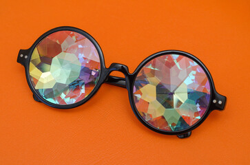 designer glasses with kaleidoscope lenses on a juicy orange background