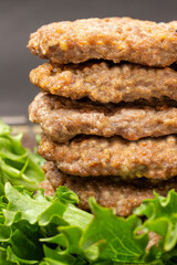 Fried burgers in stack with green salad.