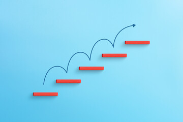 Red wooden blocks stacking as step stair with arrow up, Ladder of success in business growth concept