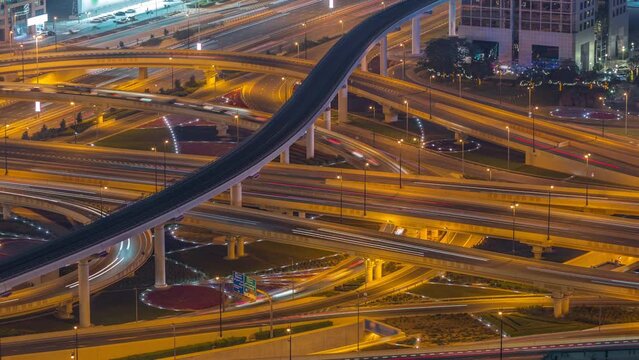 Highway intersection and overpass of Dubai downtown aerial night timelapse. Huge road junction with busy traffic from above.