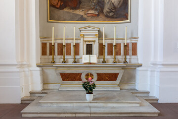 Altar with an open bible and six candles. Inside the catholic church of the Jesuits (Heidelberg).