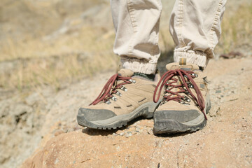 Fototapeta na wymiar Horizontal close-up of unrecognizable tourist wearing comfortable boots for hiking in mountains