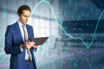  businessman with tablet and abstract glowing forex graph standing on blurry office interior background with candlestick. Invest, trade, technology and broker concept. Double exposure.