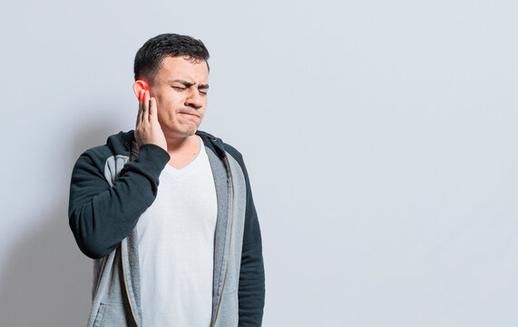 Person with ear pain, on isolated background, Suffering man massaging his ear isolated, A person with otitis and tinnitus