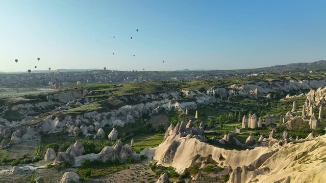 4K Aerial view of Goreme. Colorful hot air balloons fly over the valleys.