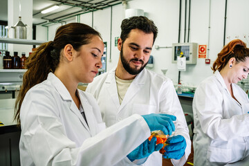 Content scientist pouring liquid in lab