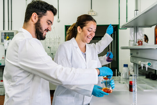 Content scientist pouring liquid in lab