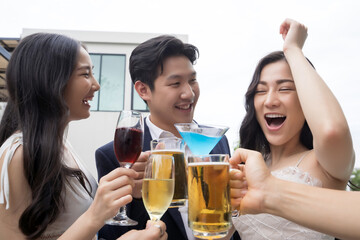 Young asian friends toasting drinks at a party