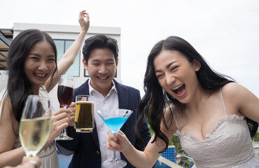 Young asian friends toasting drinks at a party