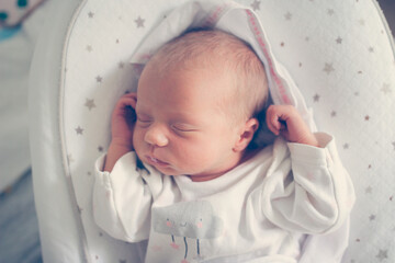 Gentle innocent newborn baby sleeps on light baby cocoon