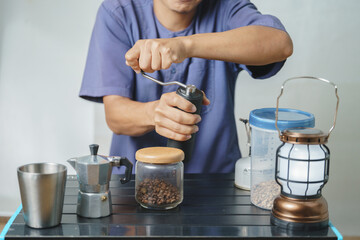 Fototapeta na wymiar Asian boy learning to make coffee with moka pot.