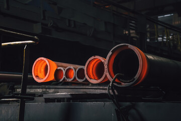 Freshly cast hot cast iron pipes at smelter. Manufacture of pipes for water, gas or oil.