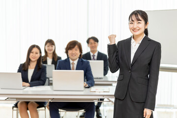 研修の講師とスーツ姿の男女（ガッツポーズ）
