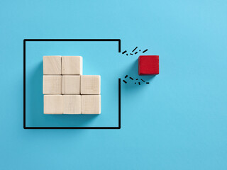 Concept of overcoming barriers, individuality and independence in business. Red wooden cube...