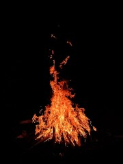 The red light from the burning bonfire in the night.